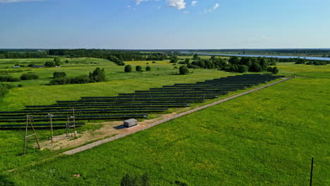 aerial view of a large solar panel farm in a green rural landscape