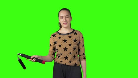 video of beginner woman with nunchucks on green isolated background