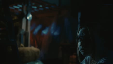 woman's scared face in dark, suspenseful setting