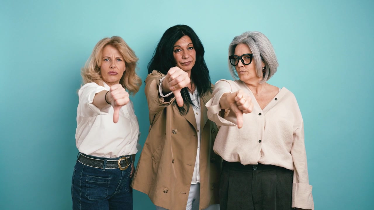 Three Mature Women Giving a Thumbs Down Gesture