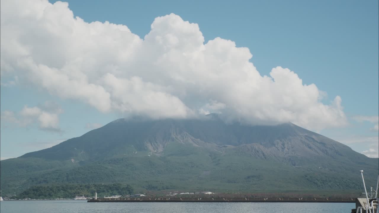 A powerful view of Sakurajima volcano releasing a thick plume of volcanic smoke in Kagoshima, Japan. Captured from across the bay.