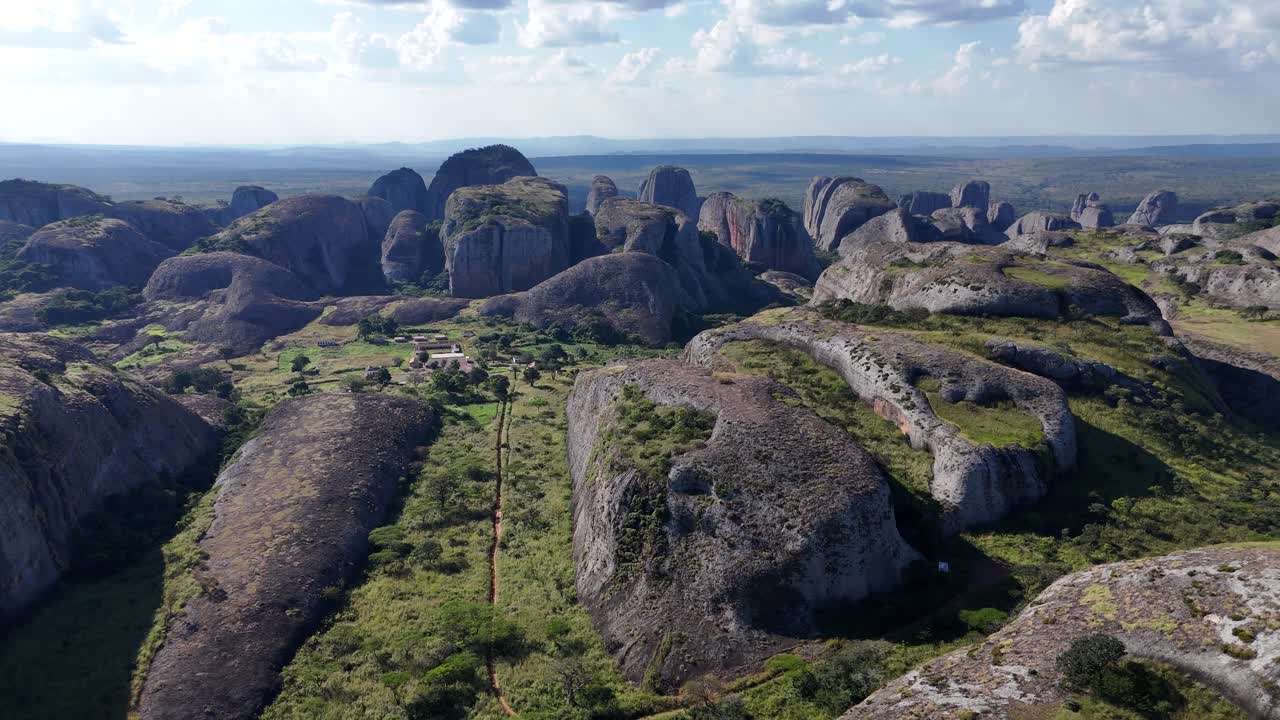 Splendido panorama aereo ad alta quota delle antiche monolitiche Pedras Negras de Pungo Andongo nella provincia di Malanje, Angola, Africa, sullo sfondo di un vasto orizzonte verde