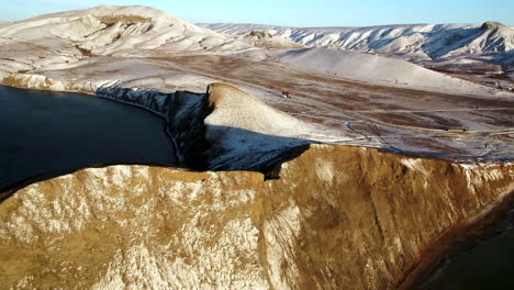 paisaje invernal de una costa rocosa con montañas cubiertas de nieve