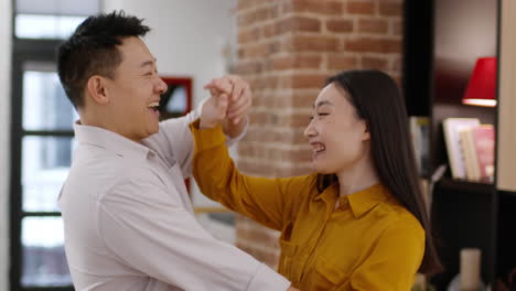 happy couple dancing and hugging at home
