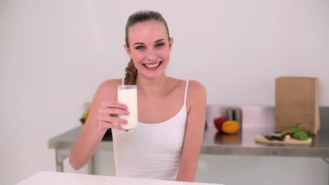 modelo sonriente bebiendo un vaso de leche