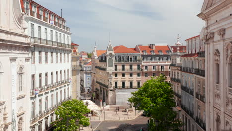 Aerial-dolly-in-street-view-of-traditional-European-houses-and-people-living-daily-lives-in-urban-city-center-of-Lisbon,-Portugal