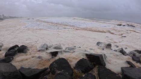 cyclone alfred - rough waves with sea foam crashing at froggies beach in queensland, australia. - pan shot
