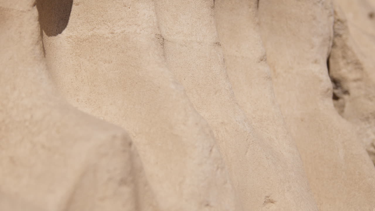 Close-up of the textured surface of ancient stone structures in Dendera, Egypt