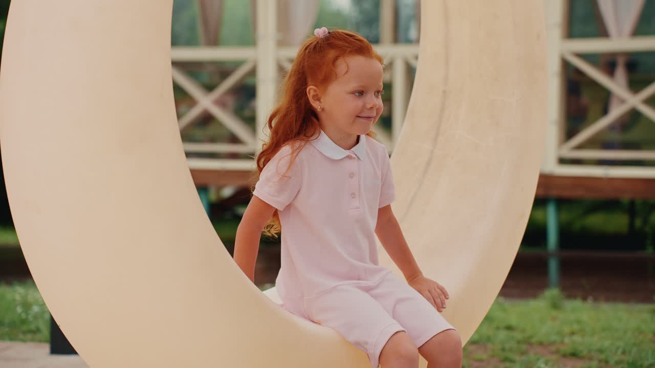 Girl Sitting on a Large Outdoor Sculpture