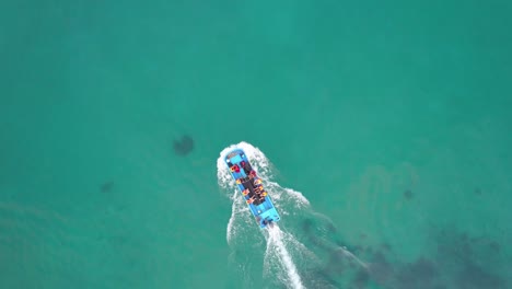 a group of people on a blue boat riding on the water