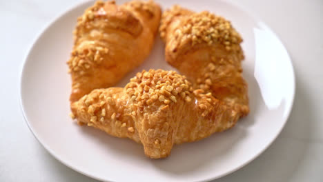 新鮮的 croissant 和花生在盤子上