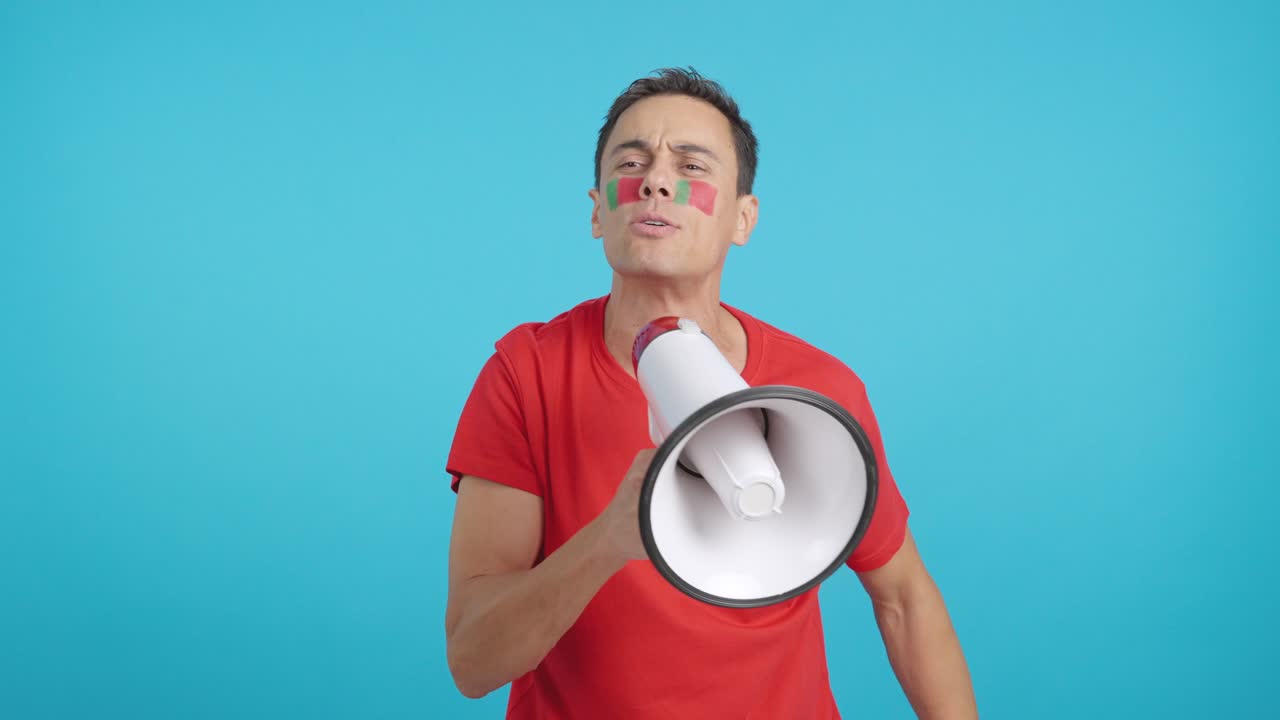 Excited man with portuguese flag on face using a megaphone