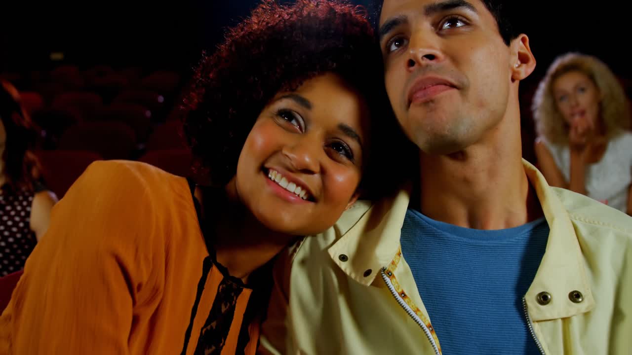 Woman feeding popcorn to man while watching movie 4k