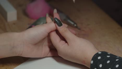 caucasian female manicurist using nail file for shaping fingernails before, close up