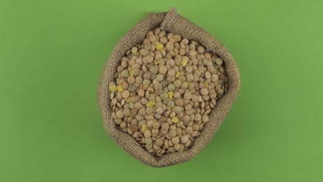 rotation of a full sack of lentil grain. top view. isolated