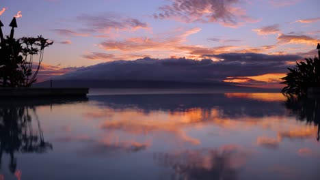 Piscina-Infinita-Hawaiana-Reflejo-De-La-Puesta-De-Sol-Detrás-De-La-Isla-Lanai-Con-Antorchas