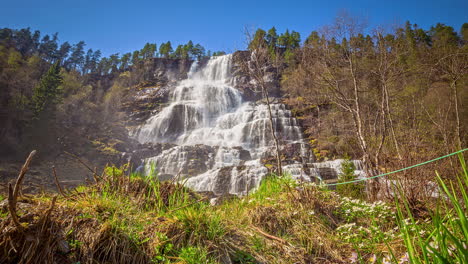 cascading waterfall in remote wilderness against blue sky