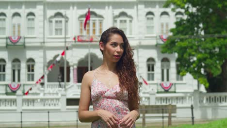 Curly-hair-girl-walks-in-a-park-with-a-castle-in-the-background