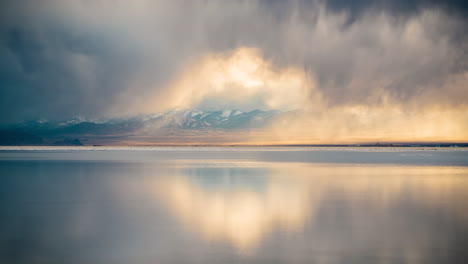 time lapse, dark clouds moving above salt flats with mirror reflection on water