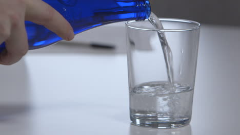 water being poured into a glass on a meeting room table in an office