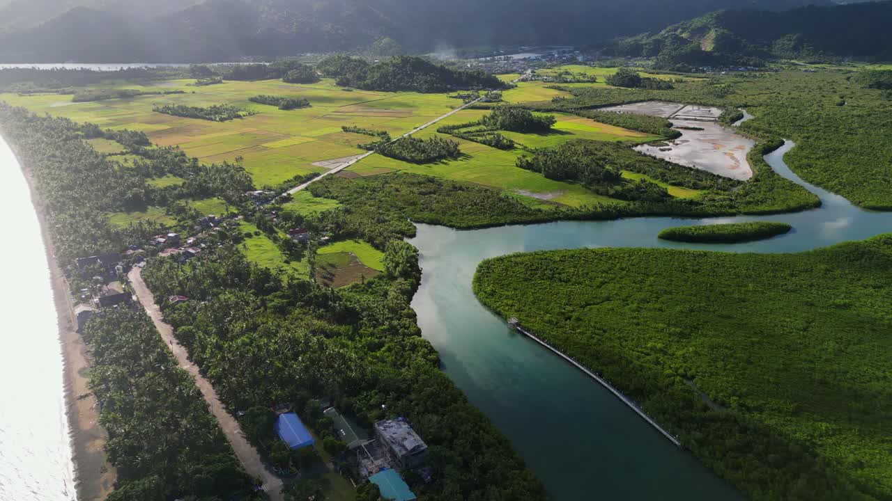 Stunning aerial flyover of a diverse tropical island community with lush valleys, mangrove forest, winding river, and hills - Bato, Catanduanes, Philippines