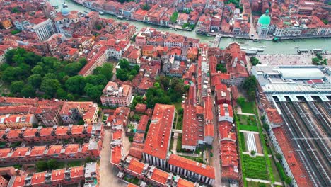 aerial view of apartments and hotels with touristic landmarks along the grand canal in venice, italy