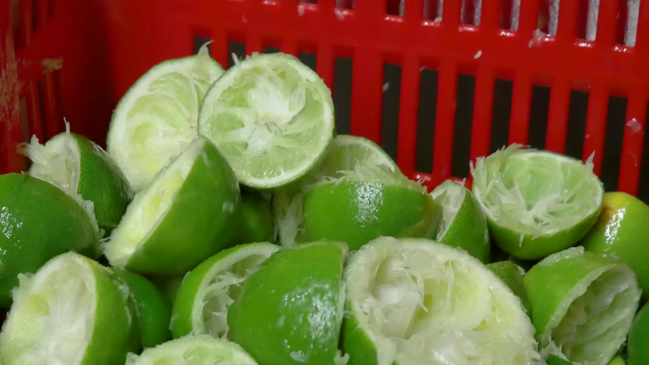Imágenes vibrantes capturan la esencia cítrica mientras mitades de limón exprimidas son hábilmente lanzadas a una caja, una explosión vibrante de energía cítrica en movimiento.