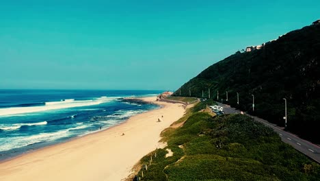 View-taken-with-a-Drone-of-the-beach-sea-with-a-car-driving-and-drone-yawing-towards-the-ocean-sea