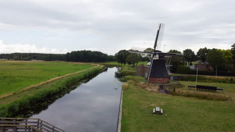 aerial view traveling out over the water mill and passing through a small wooden bridge