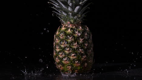 agua lloviendo sobre la piña sobre un fondo negro