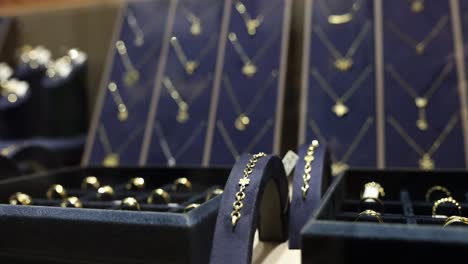 a close-up view of various gold jewelry items, including rings and necklaces, displayed in a store