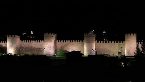 a moonlit scene of avila’s old town, highlighting the illuminated medieval walls recognized by unesco.
