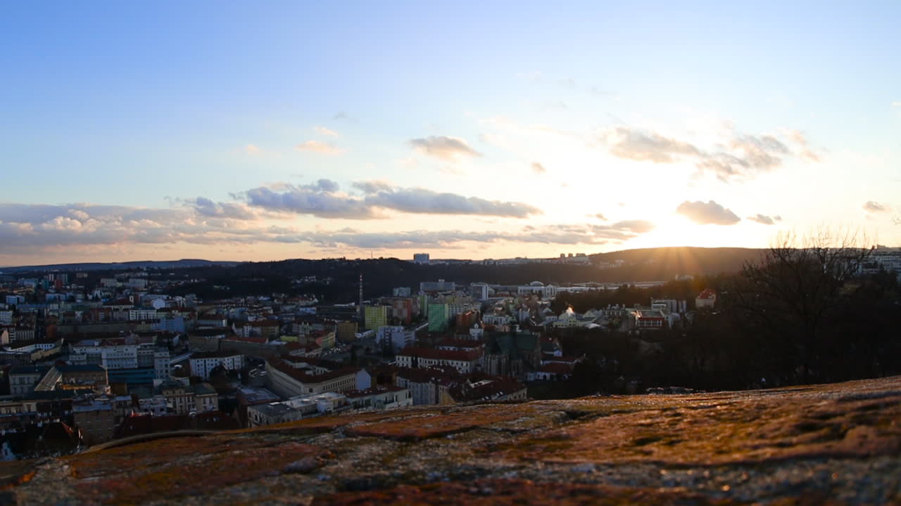 View from the city wall at sunset where you can see the square in Brno, Czech republic and the city traffic full of cars and traffic background on a copy of the setting sun rays around captured 60fps