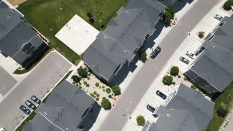 Aerial-view-looking-down-over-pristine-new-build-residential-Utah-neighbourhood-rooftops-and-gardens