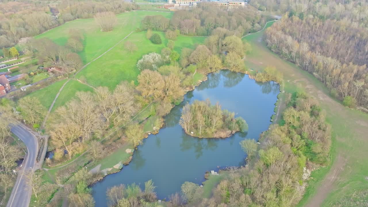 Letecký pohled na Plumpton Pond, místně zvaný Pit Pond, Netherwood Country Park, Wombwell, lesní jezero s centrálním ostrovem, což je klíčové místo pro rybaření, procházky, divokou zvěř a komunitní rekreaci
