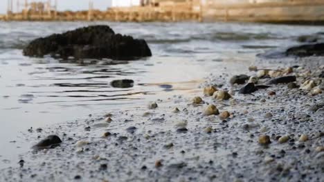 low shot of waves crashing into the pebbles of the beach-1