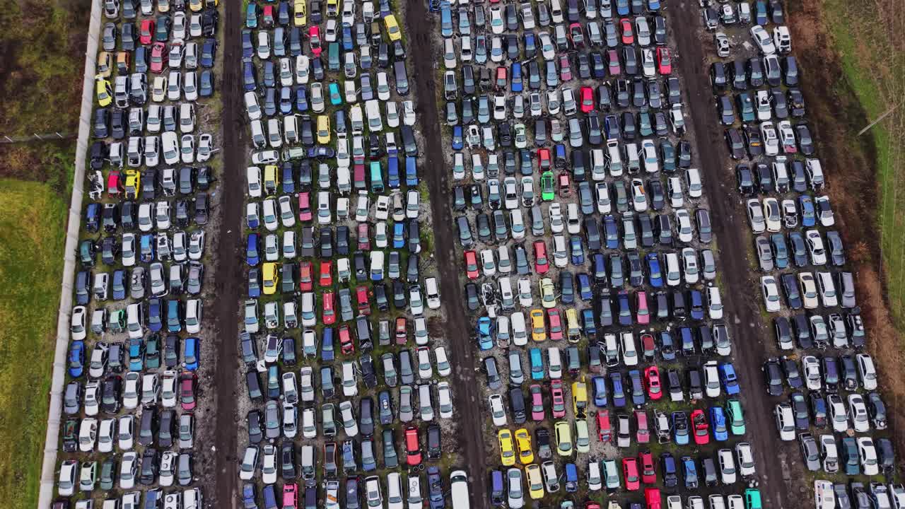 Filas de coches aparcados en un gran aparcamiento durante el día