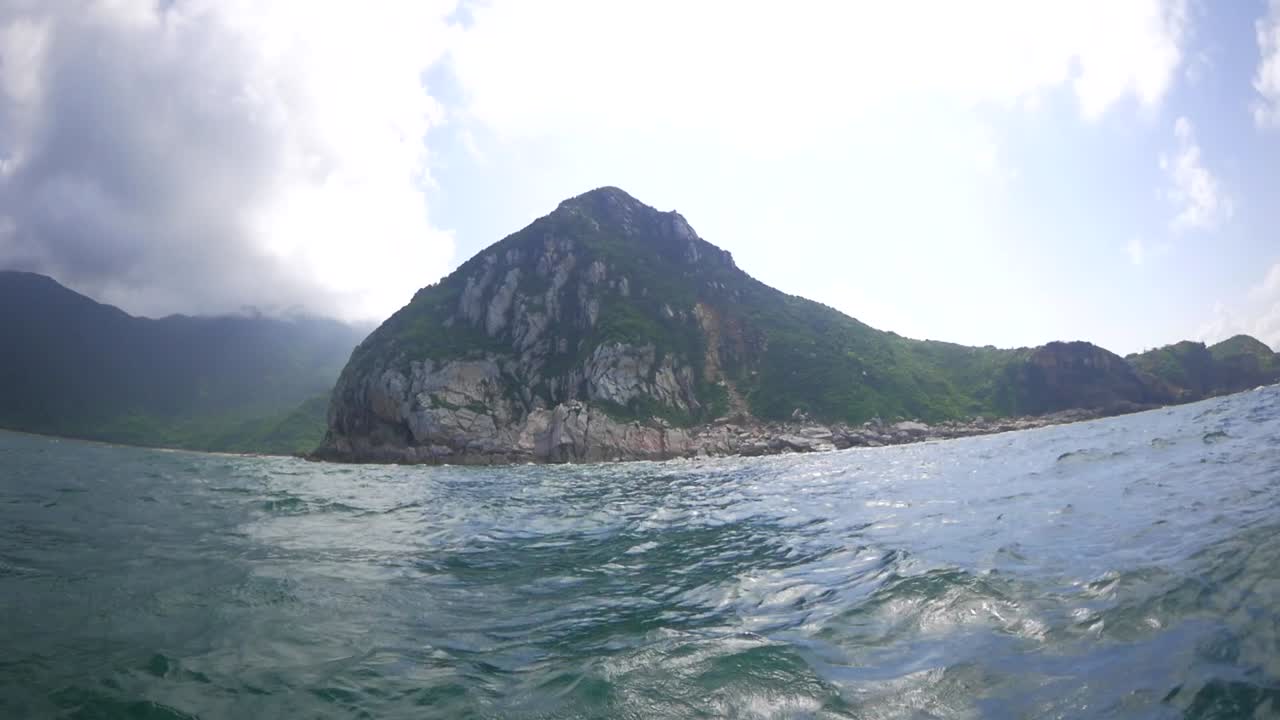 Cruising on a bumpy boat in a sea along the coast of breathtaking mountains