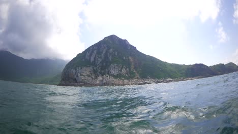 cruising on a bumpy boat in a sea along the coast of breathtaking mountains