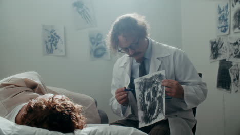 psychiatrist discussing drawing with patient in mental hospital ward
