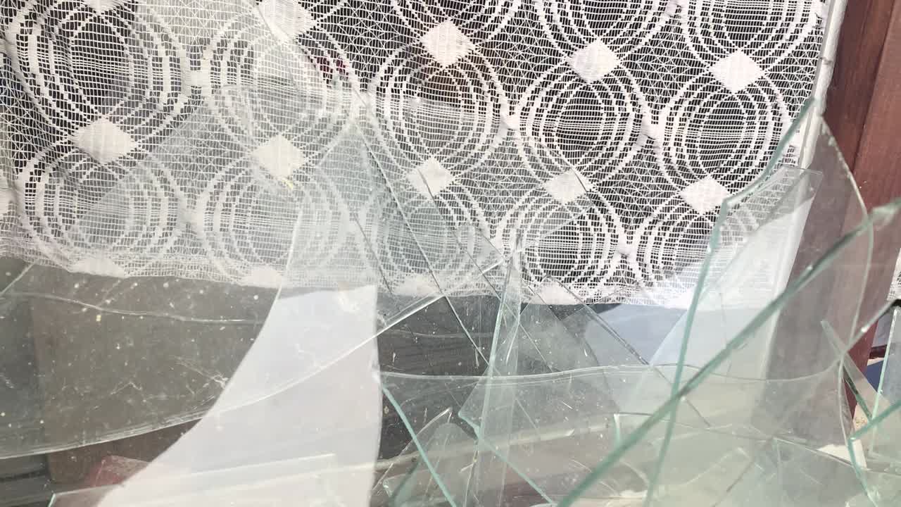 guerra entre ucrania y rusia: ventanas rotas por bombas en una antigua casa con cortinas de encaje