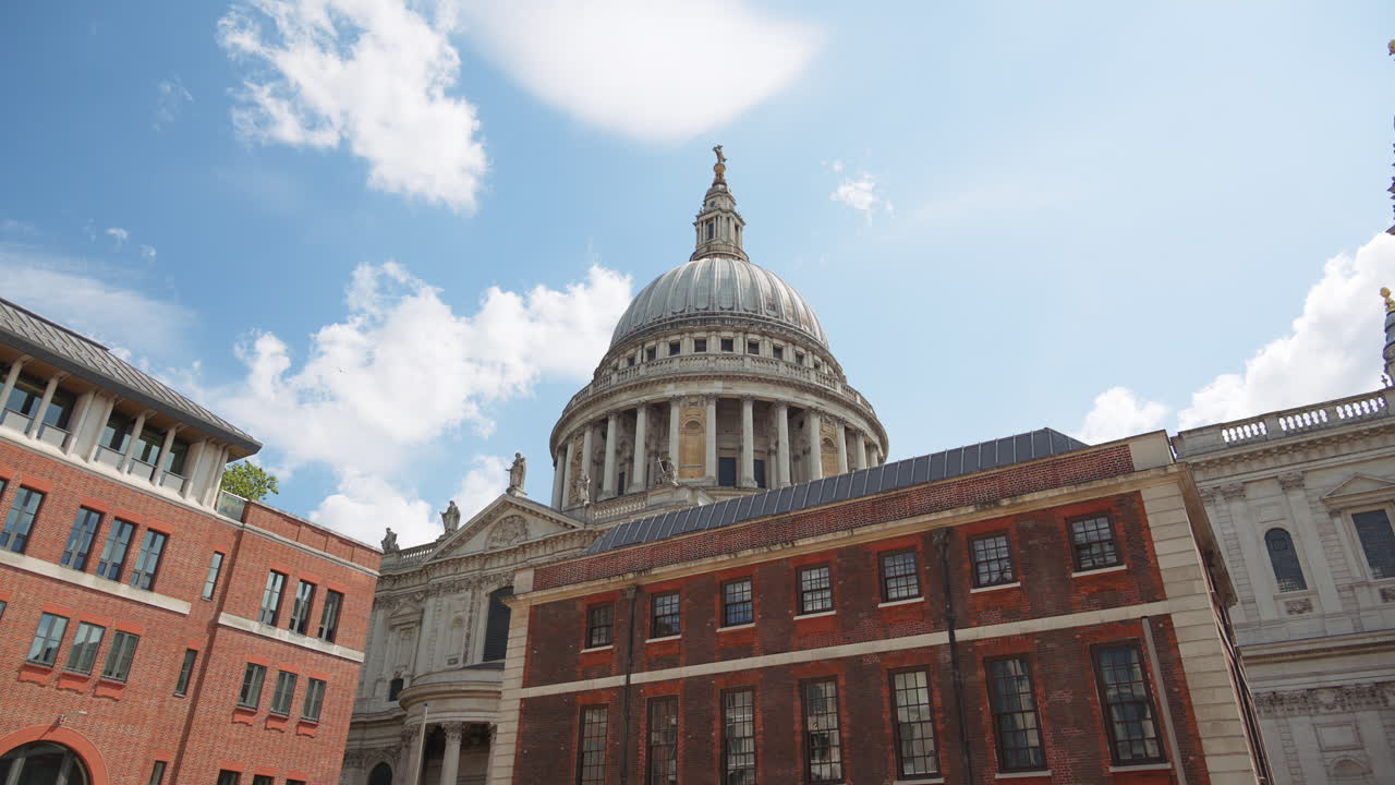 The Dome of St. Paul's Cathedral rising above the buildings with a clear blue sky in the background in London, England
