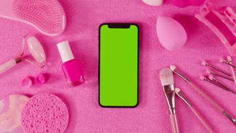 pink beauty accessories and green screen phone mockup