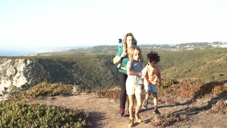 niños felices y madre activa con mochila