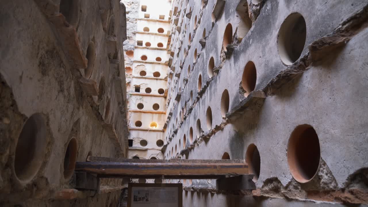 Slow tilt up of a big crumbling abandoned dovecote from the XVIII century in the south of Spain.