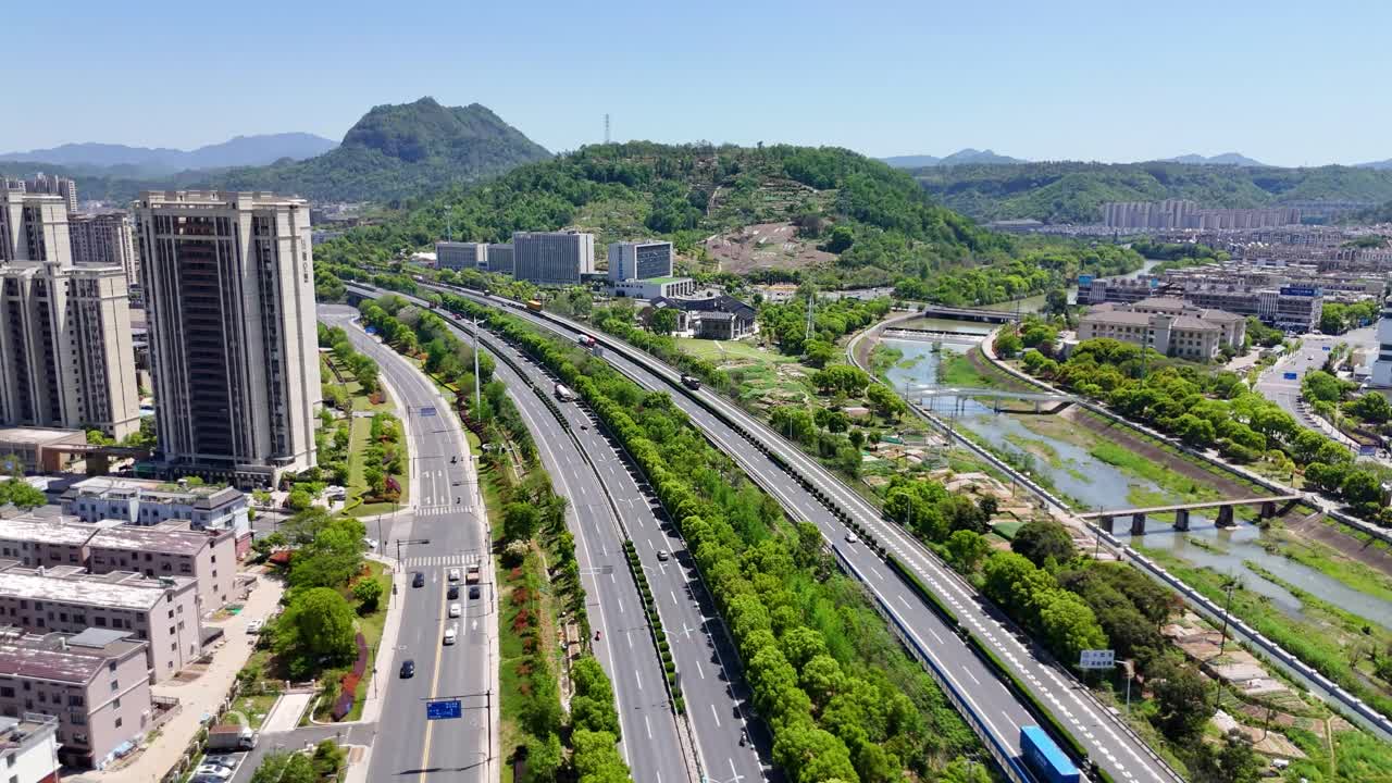Aerial view of Shaoxing in Zhejiang Province, China. Features highways, modern buildings, green hills, and rivers, blending urban and natural landscapes. UHD.