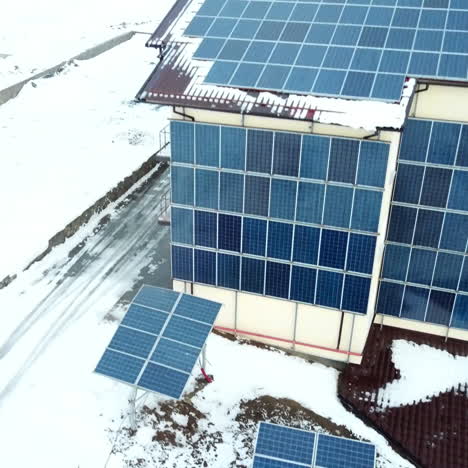hotel complex in the mountains with solar panels on the snow. rows of snow covered solar panels in a small solar power plant.