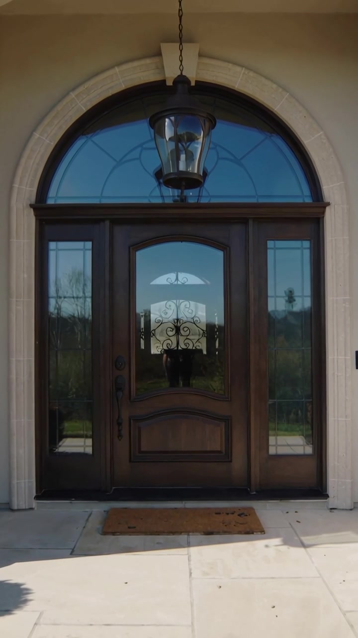 Vertical video: Shifting camera moving wood door closer at porch, revealing doormat and lantern
