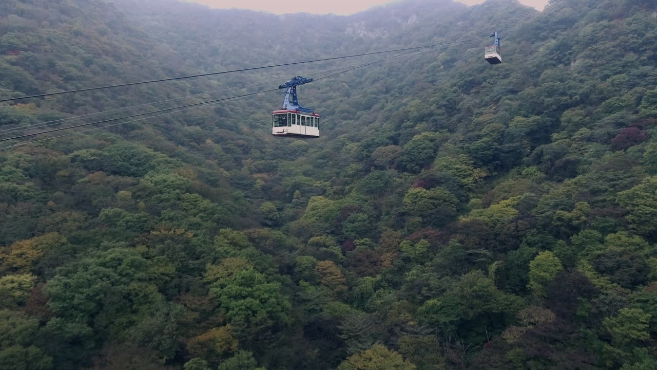 Korea, songnisan cable car, follow drone shot, low angle, cable car passing by
