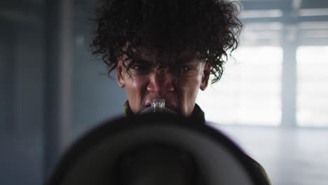 retrato de un hombre afroamericano hablando en megáfono en un garaje vacío en un garaje vacío